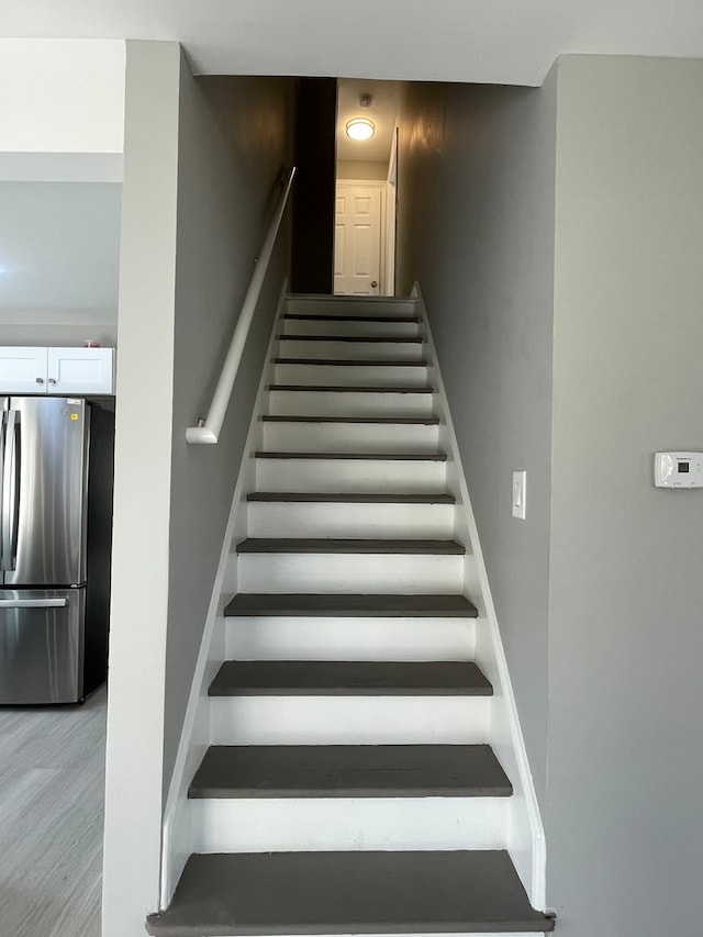 staircase with hardwood / wood-style flooring