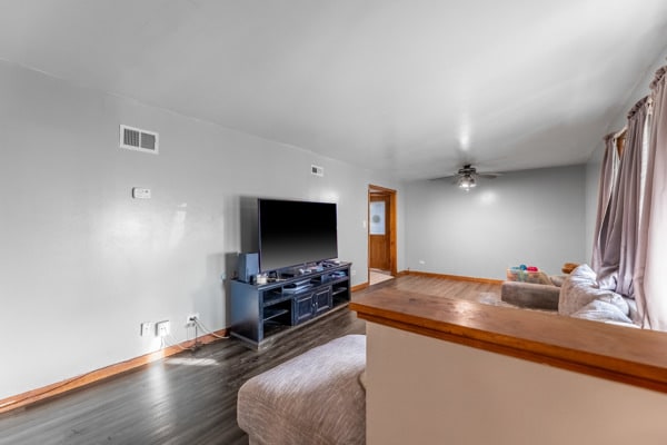 living room featuring dark hardwood / wood-style floors and ceiling fan