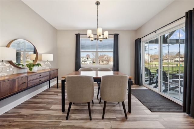 dining space featuring hardwood / wood-style floors, a wealth of natural light, and a chandelier