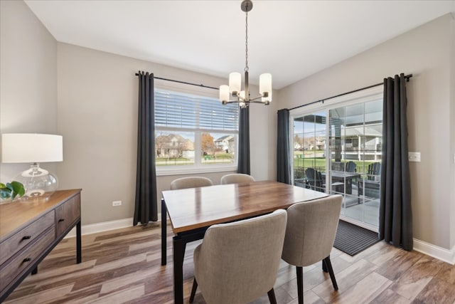 dining area with plenty of natural light, an inviting chandelier, and light wood-type flooring