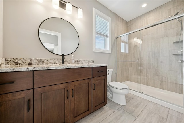 bathroom featuring tile patterned flooring, vanity, toilet, and walk in shower