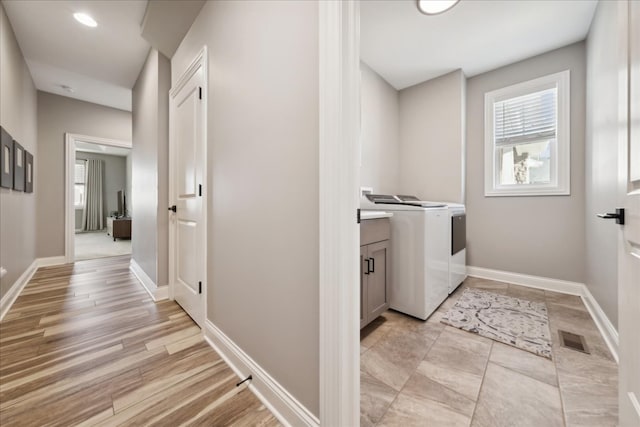 washroom with light wood-type flooring and separate washer and dryer