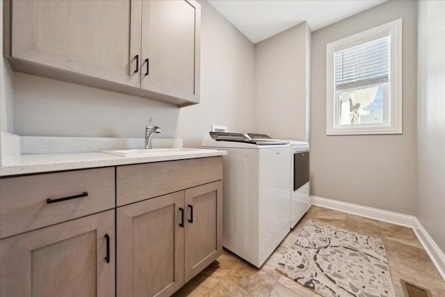 washroom featuring cabinets, washing machine and dryer, and sink