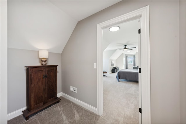 hall featuring light colored carpet and vaulted ceiling