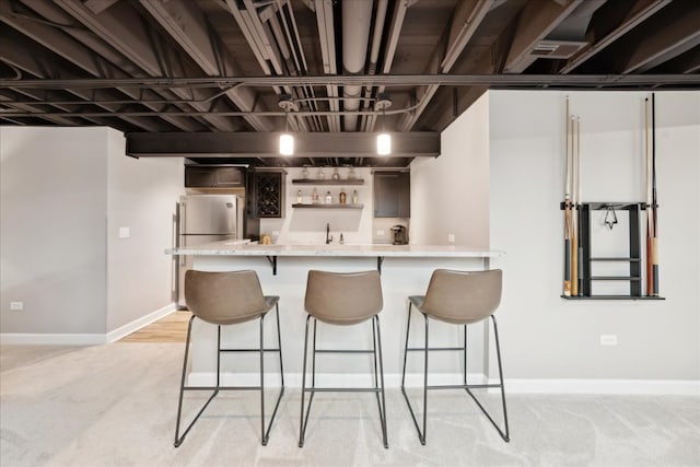 kitchen with stainless steel fridge, a breakfast bar, and light colored carpet