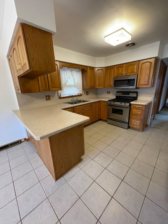 kitchen with sink, stainless steel appliances, kitchen peninsula, decorative backsplash, and light tile patterned flooring