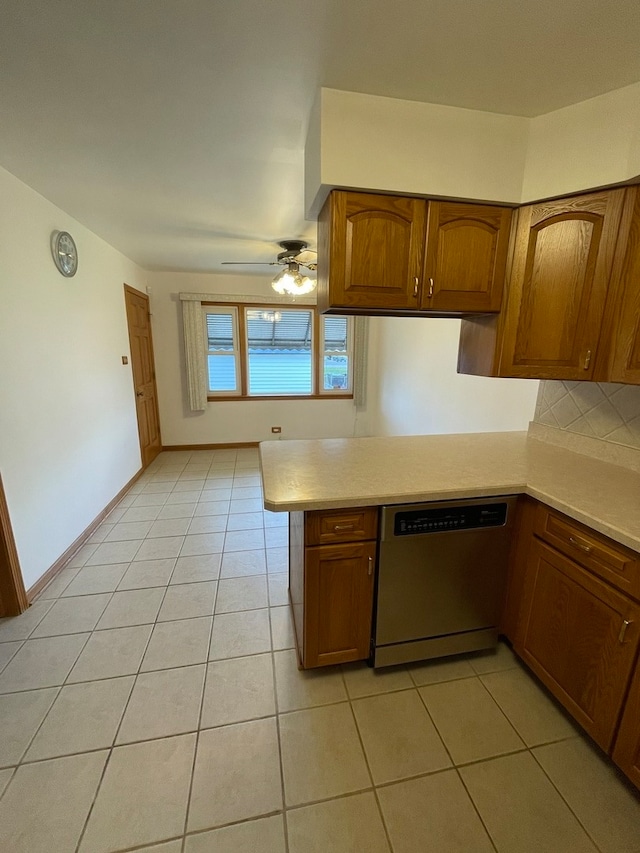 kitchen featuring stainless steel dishwasher, ceiling fan, light tile patterned floors, tasteful backsplash, and kitchen peninsula