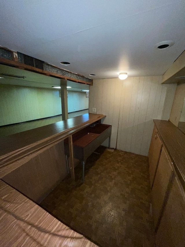 bar with dark carpet and wooden walls