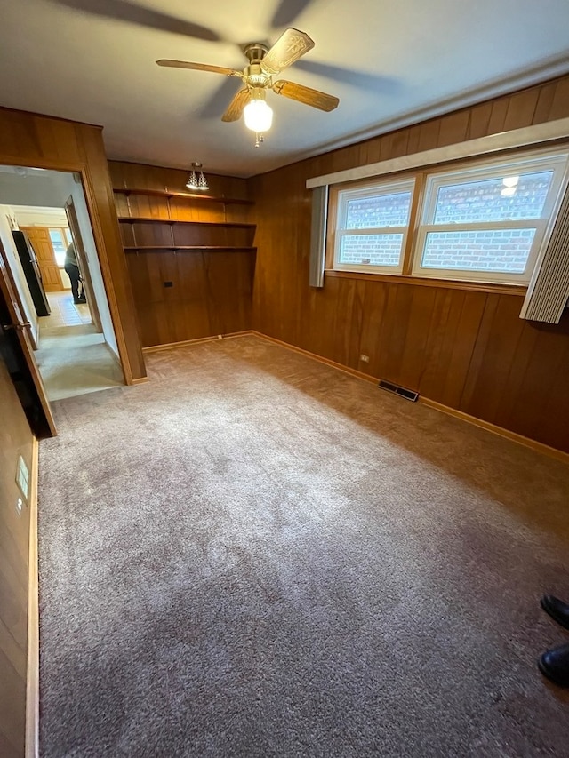 unfurnished bedroom featuring wooden walls and carpet floors