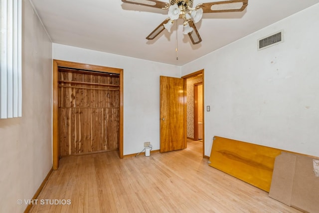 unfurnished bedroom with ceiling fan, light wood-type flooring, and a closet