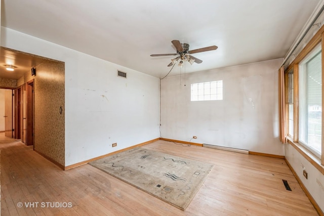 unfurnished room with ceiling fan, light wood-type flooring, and a baseboard radiator