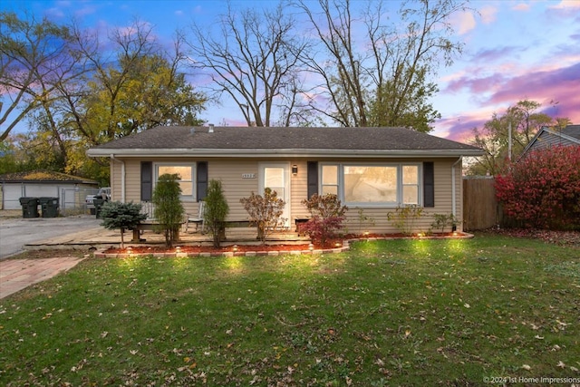 view of front of house with a yard, an outdoor structure, and a garage