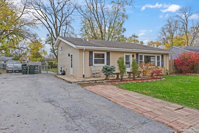 single story home featuring a front lawn and fence