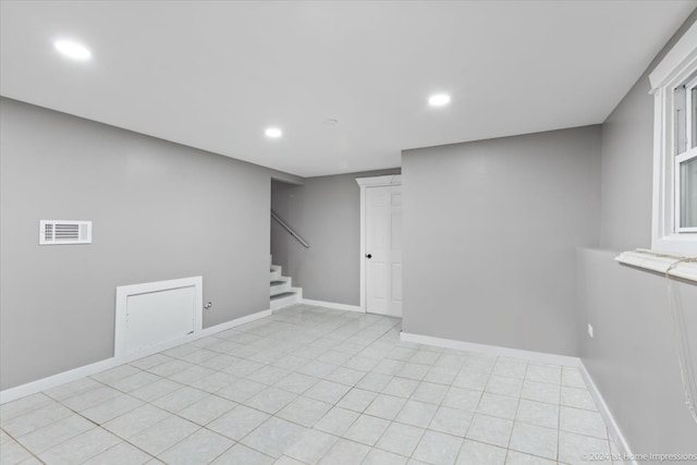 below grade area with visible vents, recessed lighting, light tile patterned floors, baseboards, and stairs