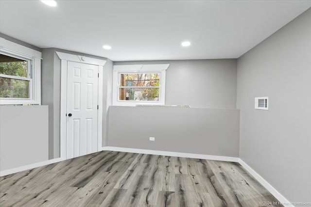 unfurnished room with plenty of natural light, recessed lighting, baseboards, and wood finished floors