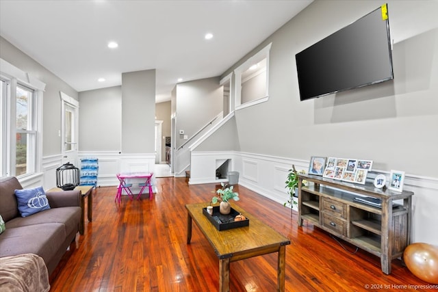 living room with hardwood / wood-style floors, recessed lighting, stairs, wainscoting, and a decorative wall