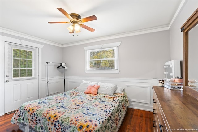 bedroom featuring ceiling fan, dark wood-type flooring, ornamental molding, and wainscoting