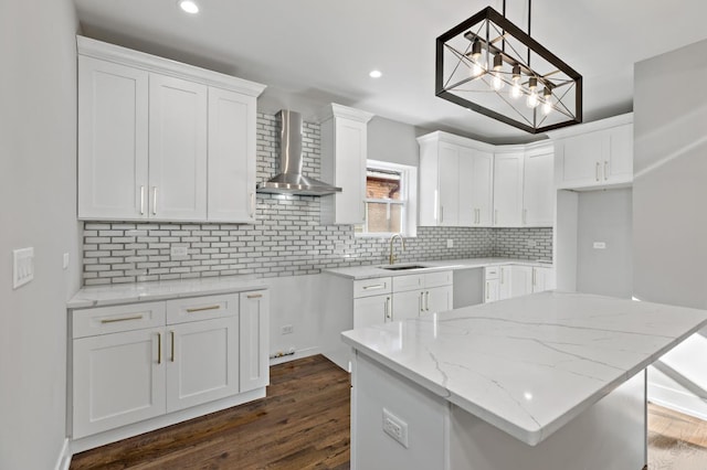 kitchen featuring a center island, sink, wall chimney range hood, dark hardwood / wood-style flooring, and white cabinets