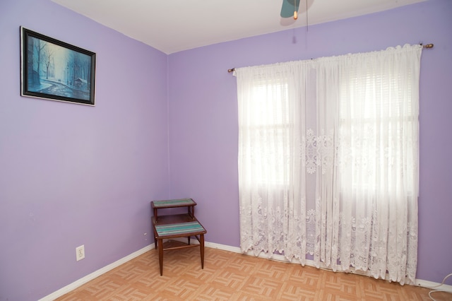 unfurnished room with ceiling fan and light parquet floors