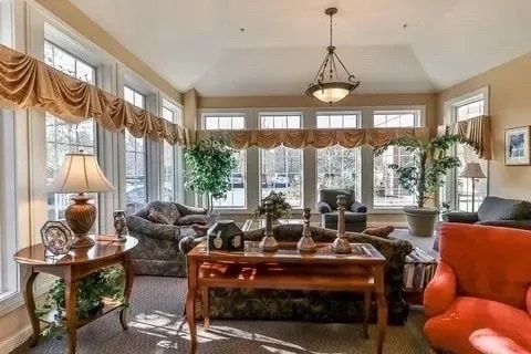 sunroom with a healthy amount of sunlight and vaulted ceiling