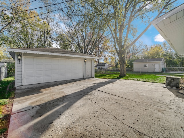 garage featuring a lawn and central AC