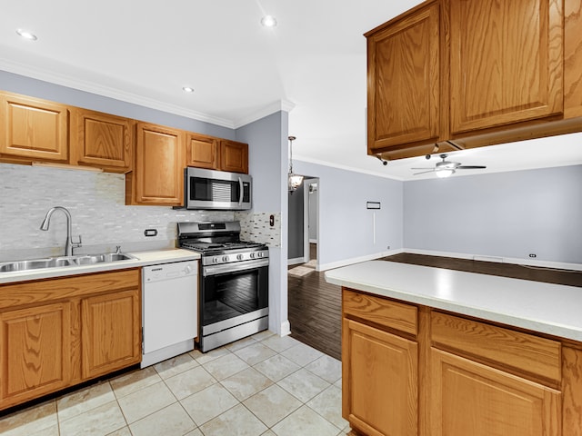 kitchen featuring appliances with stainless steel finishes, light tile patterned floors, ornamental molding, and sink