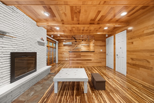 interior space featuring beam ceiling, hardwood / wood-style flooring, wooden walls, and wood ceiling