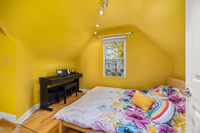 bedroom featuring hardwood / wood-style floors and vaulted ceiling