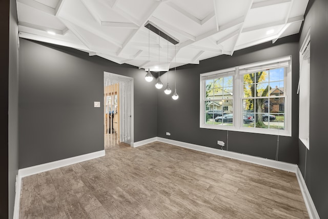 spare room featuring beam ceiling and hardwood / wood-style flooring