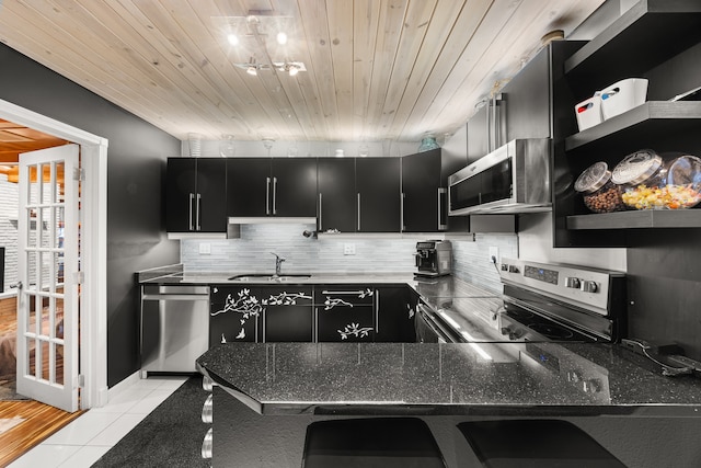 kitchen featuring light tile patterned floors, stainless steel appliances, wooden ceiling, and sink