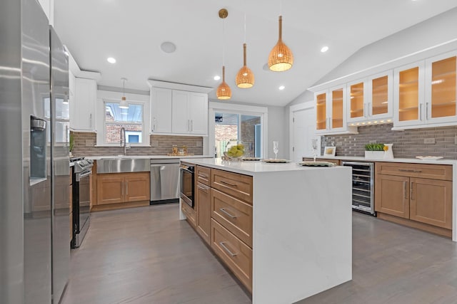 kitchen with pendant lighting, white cabinetry, a center island, and stainless steel appliances