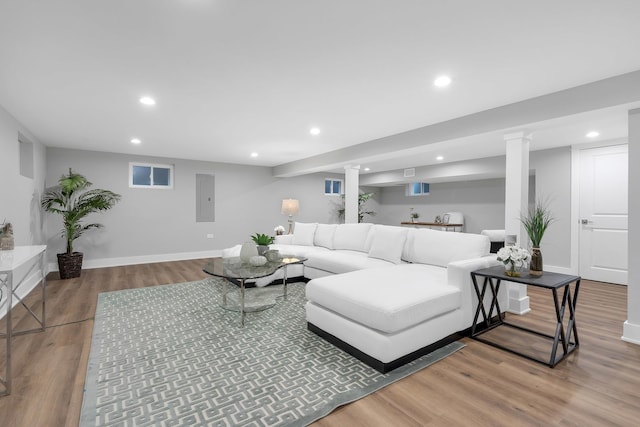 living room featuring decorative columns, hardwood / wood-style floors, and electric panel