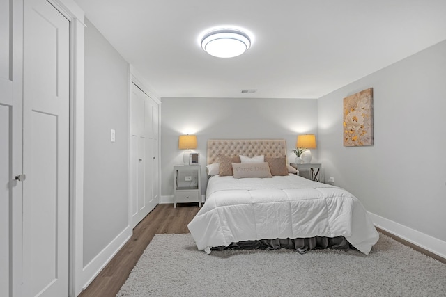 bedroom with dark hardwood / wood-style flooring