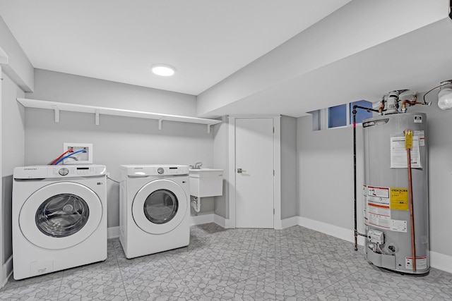 laundry area featuring sink, washing machine and dryer, and water heater