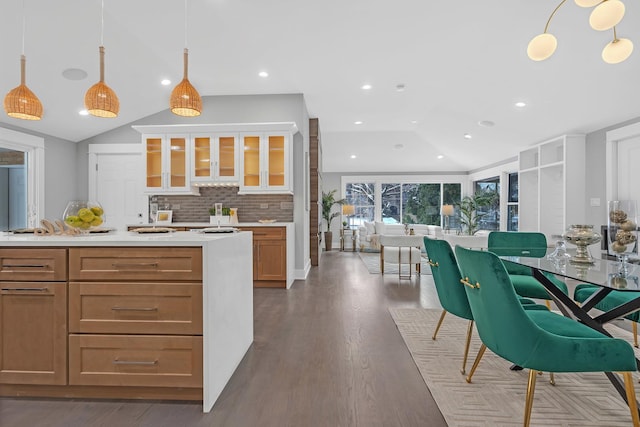 kitchen with hardwood / wood-style flooring, lofted ceiling, tasteful backsplash, and hanging light fixtures