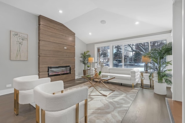 living room featuring wood-type flooring, a large fireplace, and lofted ceiling