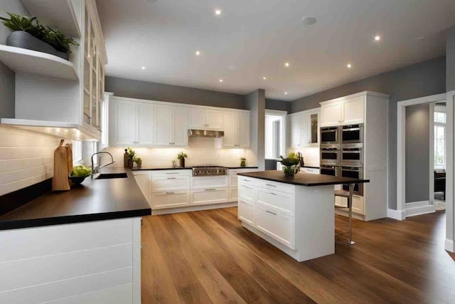 kitchen featuring white cabinetry, a center island, and sink