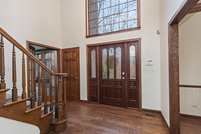 foyer with dark wood-type flooring and a high ceiling