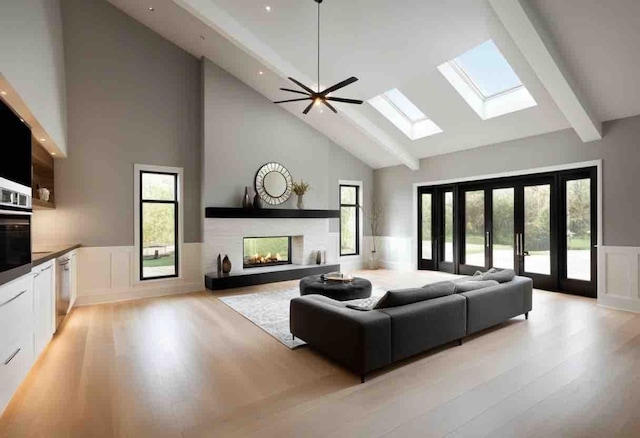 living room with ceiling fan, a multi sided fireplace, a high ceiling, and french doors