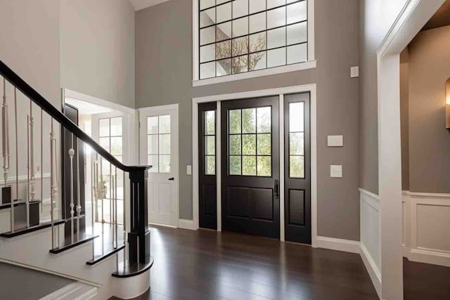 foyer entrance featuring a high ceiling and dark hardwood / wood-style flooring