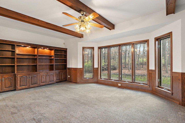 unfurnished living room featuring beam ceiling, light carpet, and ceiling fan