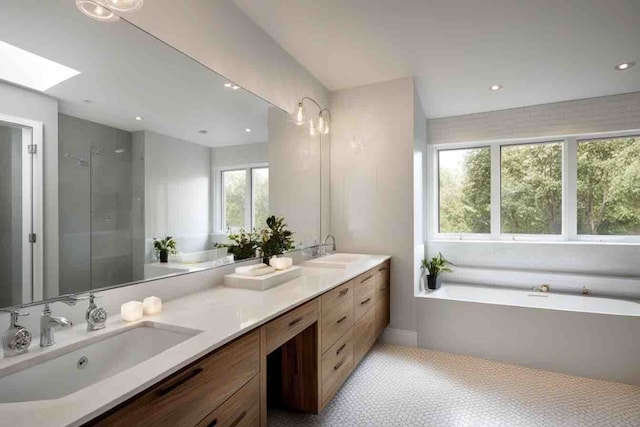 bathroom with a skylight, a wealth of natural light, vanity, and independent shower and bath