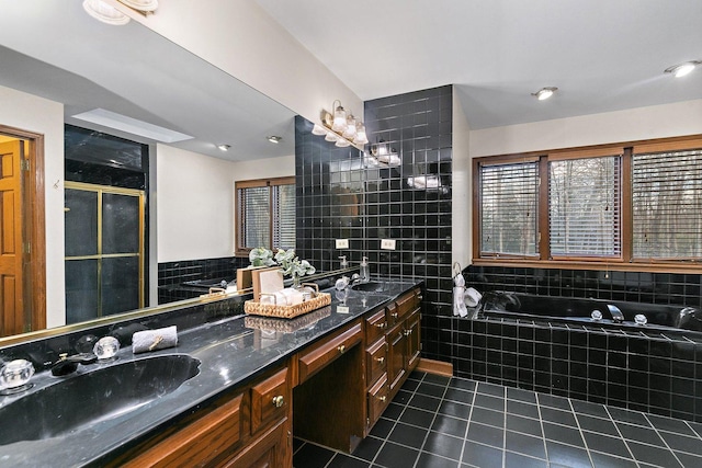 bathroom featuring tile patterned flooring, vanity, tile walls, and plus walk in shower