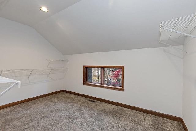 walk in closet with carpet and vaulted ceiling