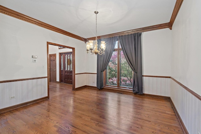 unfurnished room with dark hardwood / wood-style flooring, ornamental molding, and an inviting chandelier