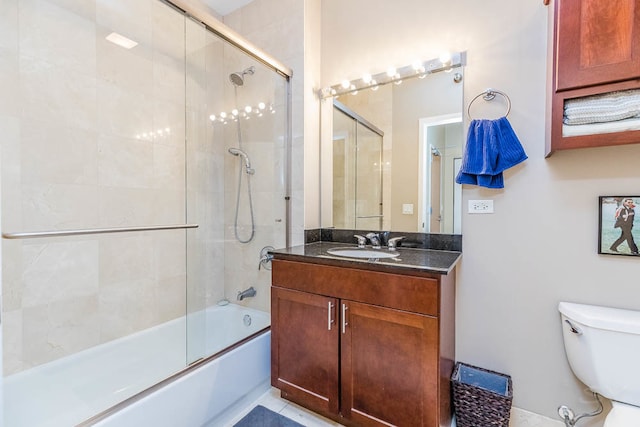 full bathroom with tile patterned floors, vanity, toilet, and shower / bath combination with glass door