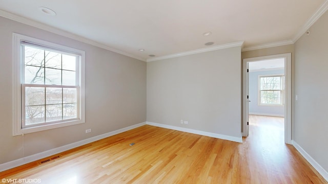 empty room with plenty of natural light, ornamental molding, and light wood-type flooring