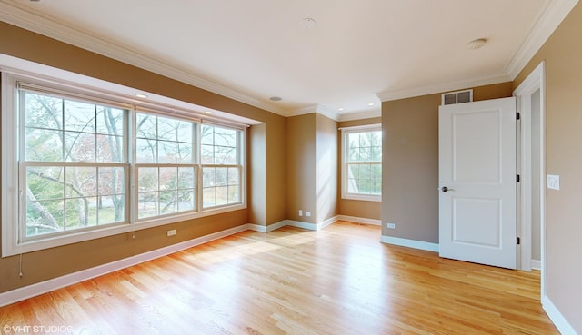 unfurnished room with plenty of natural light, ornamental molding, and light hardwood / wood-style flooring