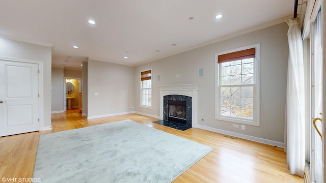 living room featuring light hardwood / wood-style floors, a premium fireplace, and ornamental molding