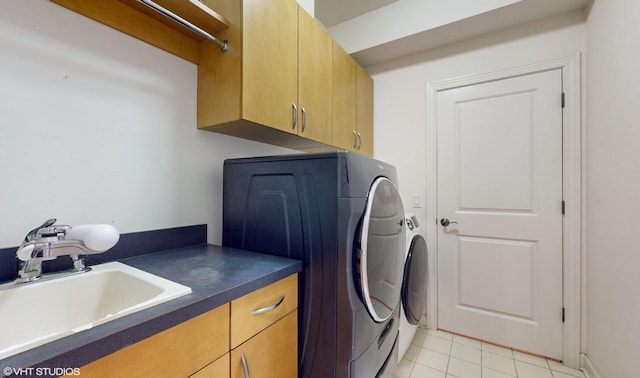 laundry room with cabinets, light tile patterned floors, washing machine and dryer, and sink